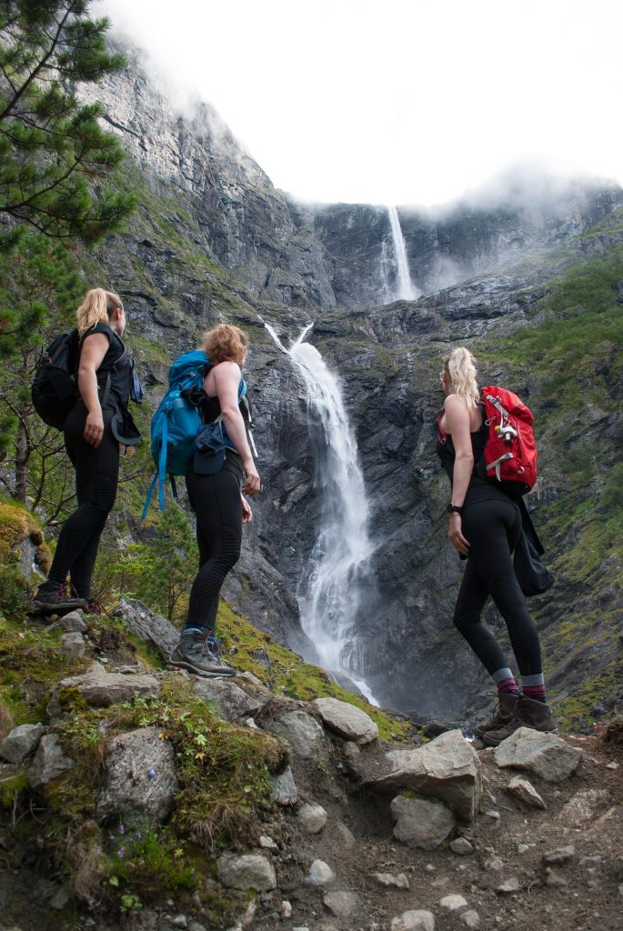 Drie vriendinnen poseren voor de Mardalsfossen waterval in Noorwegen
