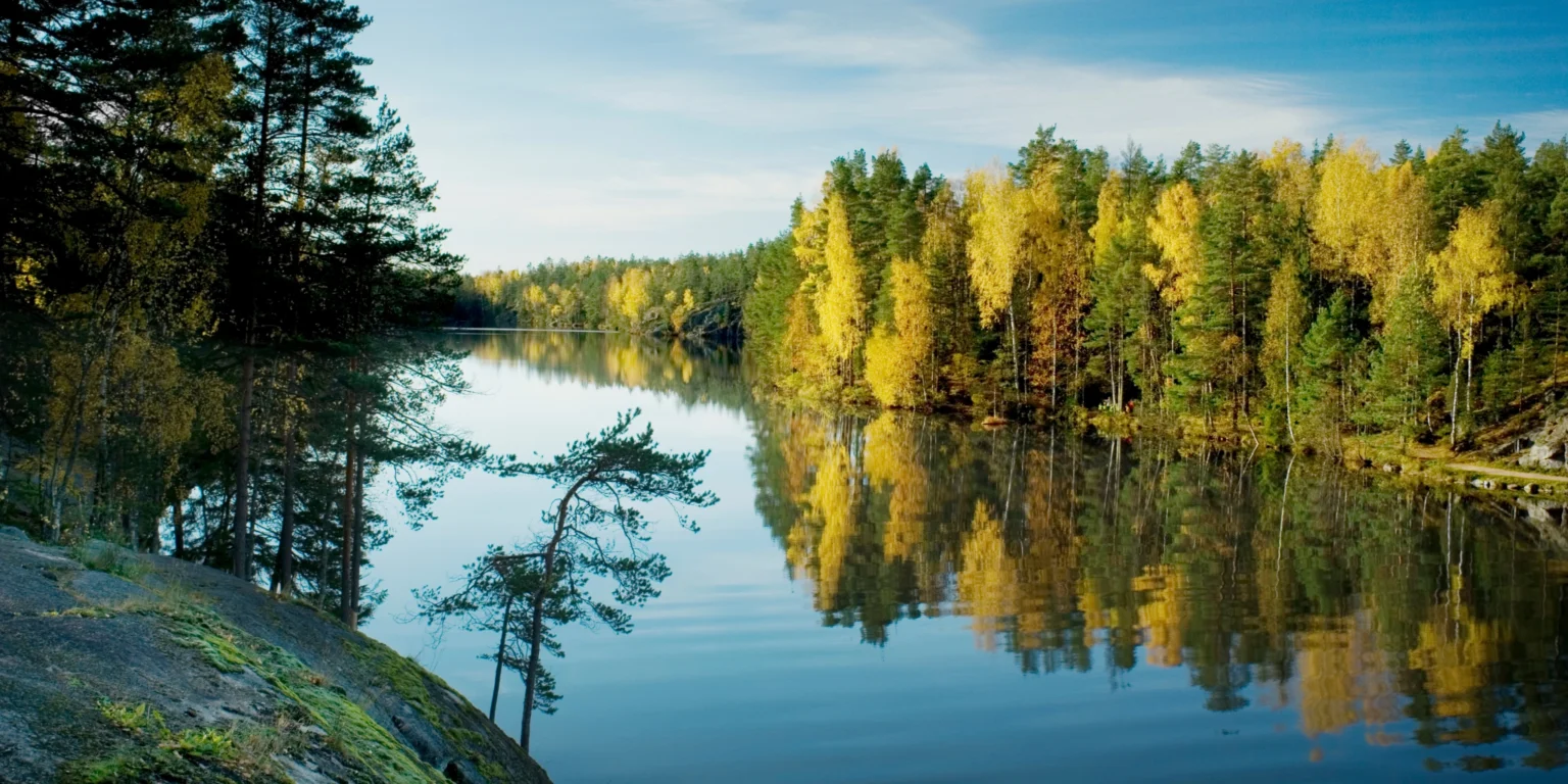Quiet Finnish lake with autumn-coloured forests reflected in the water