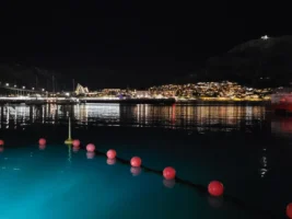 Uitzicht over de verlichte haven van Tromso op een donkere winterdag